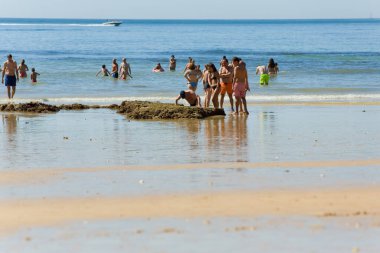 ALBUFEIRA, PORTUGAL - 22 Ağustos 2017: Albufeira 'daki Praia da Felesia' nın ünlü plajındaki insanlar. Bu plaj Algarve 'nin ünlü turistik bölgesinin bir parçasıdır..