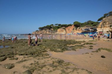 ALBUFEIRA, PORTUGAL - 23 Ağustos 2016: Albufeira 'nın ünlü Olhos de Agua plajındaki insanlar. Bu plaj Algarve 'nin ünlü turistik bölgesinin bir parçasıdır..