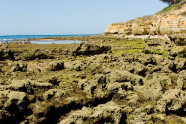 ALBUFEIRA, PORTUGAL - 20 Ağustos 2016: Albufeira 'nın ünlü Olhos de Agua plajındaki insanlar. Bu plaj Algarve 'nin ünlü turistik bölgesinin bir parçasıdır..