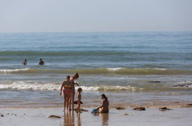 ALBUFEIRA, PORTUGAL - 22 Ağustos 2017: Albufeira 'daki ünlü Olhos de Agua plajındaki insanlar. Bu plaj Algarve 'nin ünlü turistik bölgesinin bir parçasıdır..
