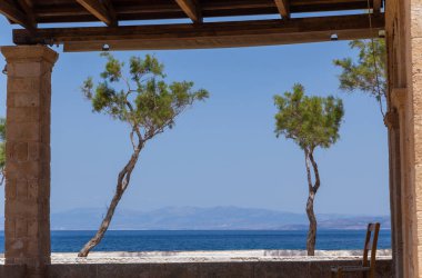 Yunanistan 'ın Saronik körfezinde Akdeniz' in berrak ve mavi sularıyla Aegina adasının kıyıları.