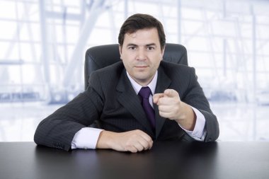 Genç bir iş adamı büroda, masanın üstünde.