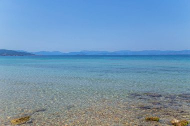 Yunanistan 'ın Saronik körfezinde Akdeniz' in berrak ve mavi sularıyla Aegina adasının kıyıları.