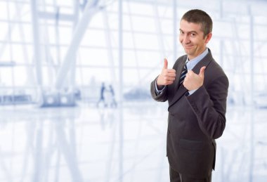 Mutlu iş adamı ofiste başparmağını kaldırıyor.