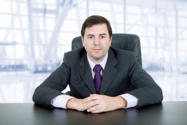 Genç bir iş adamı büroda, masanın üstünde.