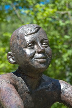 bir taş üzerinde oturan erkek heykeli