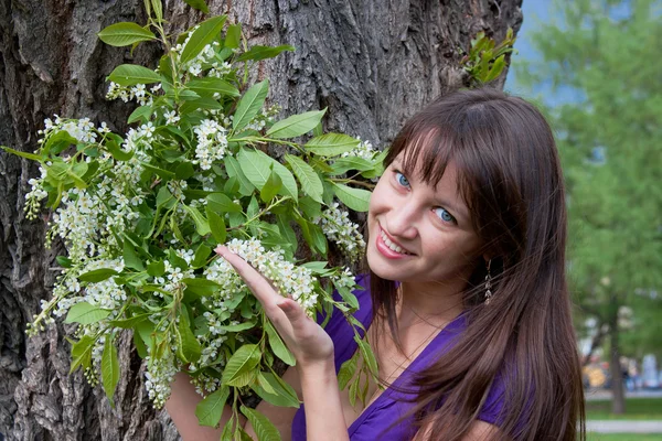 Woman on nature in a park with the sprigs of flowering bird cher — Stock Photo, Image