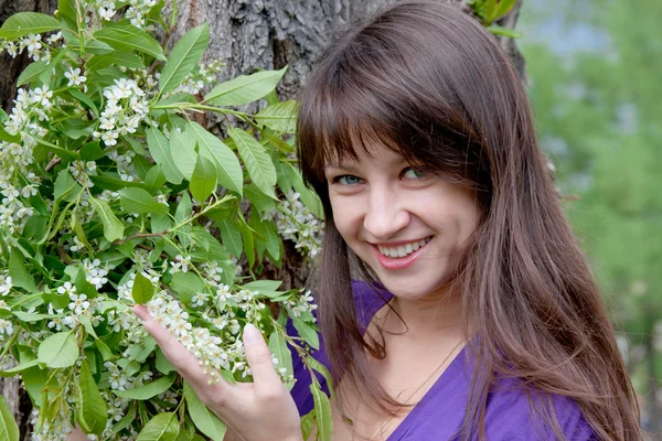 Woman on nature in a park with the sprigs of flowering bird cher — Stock Photo, Image