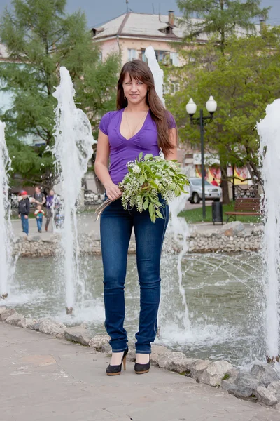 Woman on nature in a park with the sprigs of flowering bird cher — Stock Photo, Image
