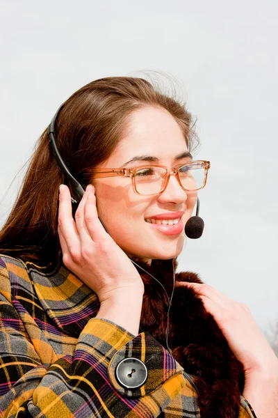 Kobieta w okularach z słuchawkami na białym tle — Zdjęcie stockowe