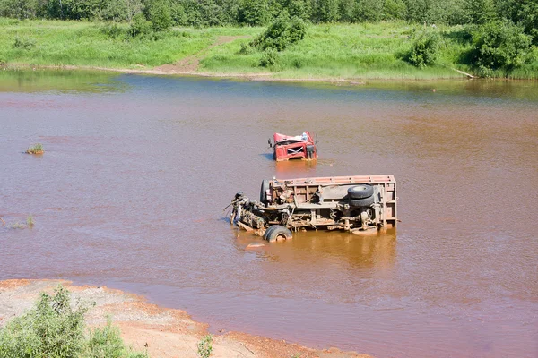 De kapotte truck ligt in vuil water — Stockfoto