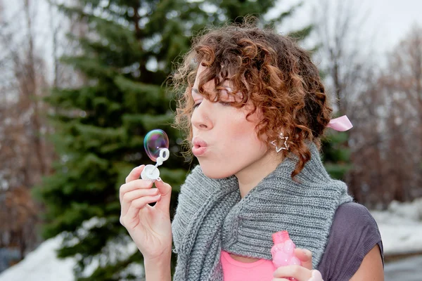 Jonge vrouw in een park klap bubbels — Stockfoto