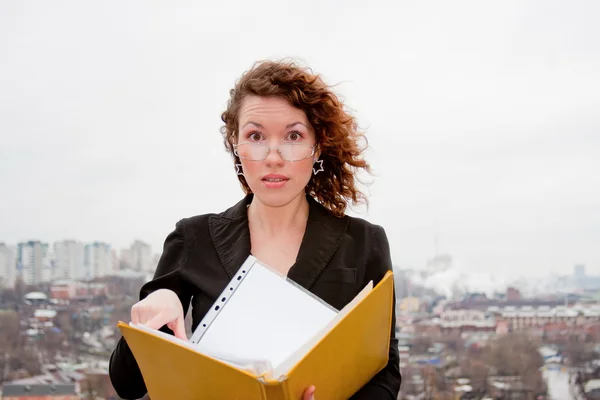 Young businesswoman with documents in hand against — Stock Photo, Image