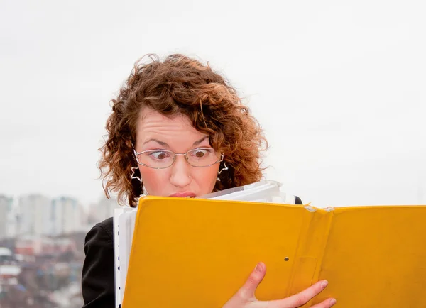 Jeune femme d'affaires avec des documents en main contre — Photo