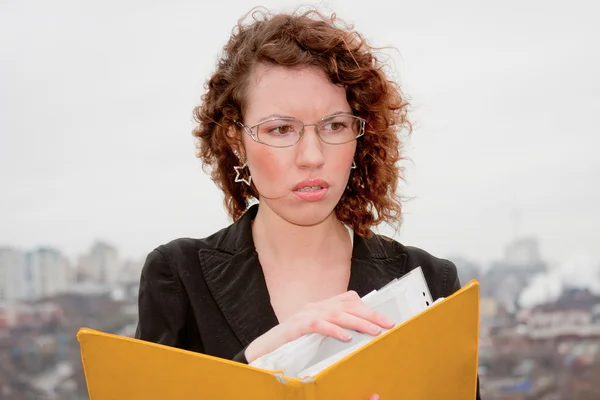 Jonge zakenvrouw met documenten in de hand tegen — Stockfoto