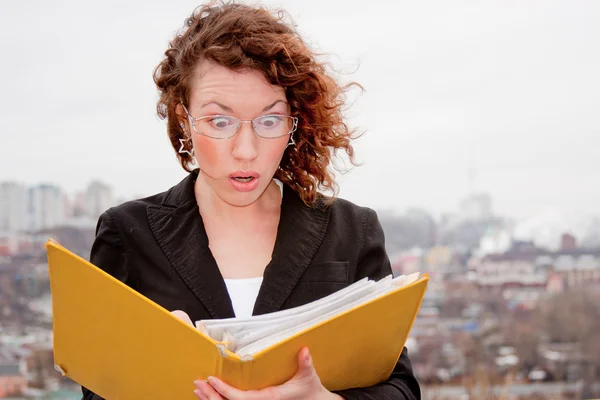 Jonge zakenvrouw met documenten in de hand tegen — Stockfoto