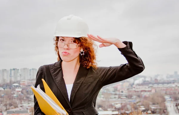 Young business woman in a helmet and documents in their hands — Stock Photo, Image