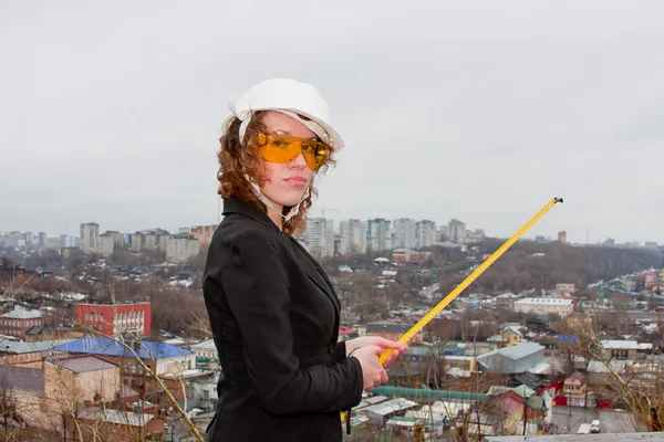 Mujer de negocios con casco y gafas con cinta métrica en han — Foto de Stock