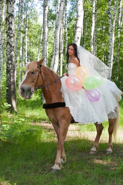 Jovem mulher no vestido de noiva em um cavalo — Fotografia de Stock