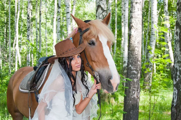 Young woman in the dress of fiancee next to a horse — Stock Photo, Image