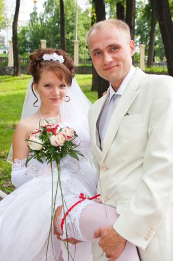 bir damat ve nişanlısı bir jartiyer ve hakkında göster