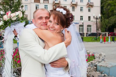 damat ve nişanlısı bir çeşme, bir parkta