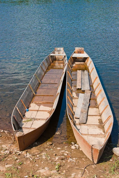 Два дерев'яні човни на березі річки — стокове фото