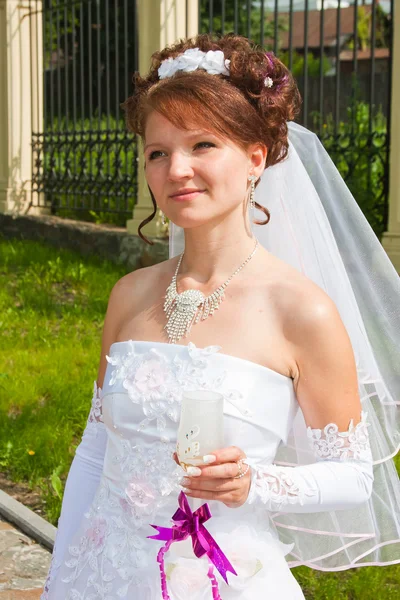 Glückliche Verlobte bei einem Spaziergang in einem Park mit einem Glas Champagner in der Hand — Stockfoto