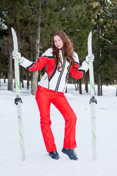 Mulher em um terno esportivo com esquis em campo — Fotografia de Stock