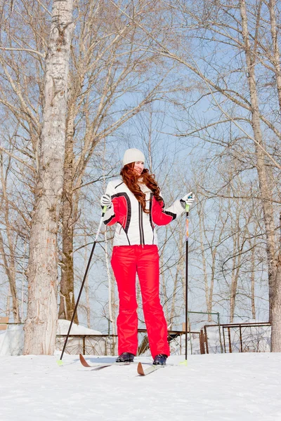 Mulher de fato desportivo em esquis em campo — Fotografia de Stock
