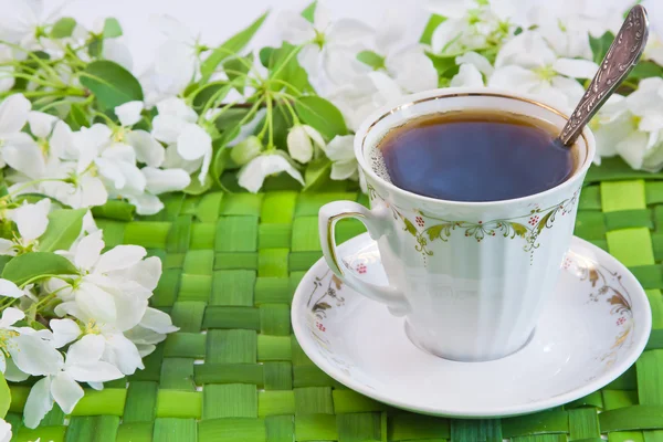 Kopp kaffe med kvistar av blommande äppelträd — Stockfoto