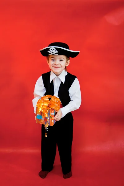 Маленький хлопчик у костюмі пірата з подарунком в руках — стокове фото