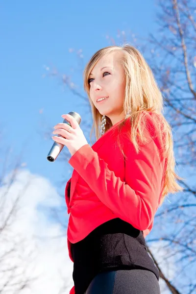 Mulher bonita com um microfone nas mãos — Fotografia de Stock