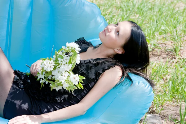 Una joven hermosa mujer en la naturaleza por un día soleado canicular se sienta —  Fotos de Stock