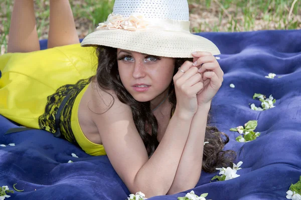 एक युवा सुंदर महिला एक पार्क में प्रकृति पर एक Inflatable चटाई पर lies — स्टॉक फ़ोटो, इमेज