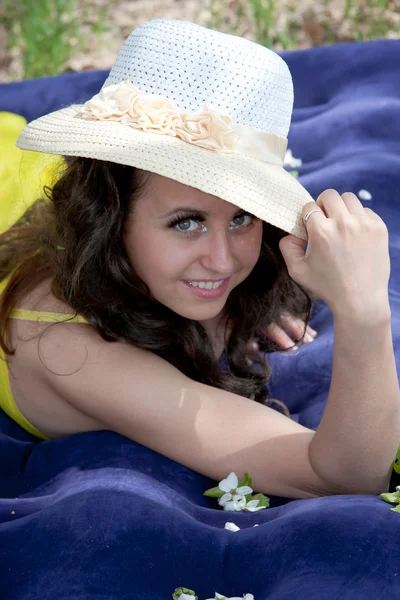 Una mujer hermosa joven miente en un colchón inflable en la naturaleza en un parque — Foto de Stock