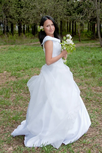 Jovem mulher no vestido de noiva no verão em um parque — Fotografia de Stock