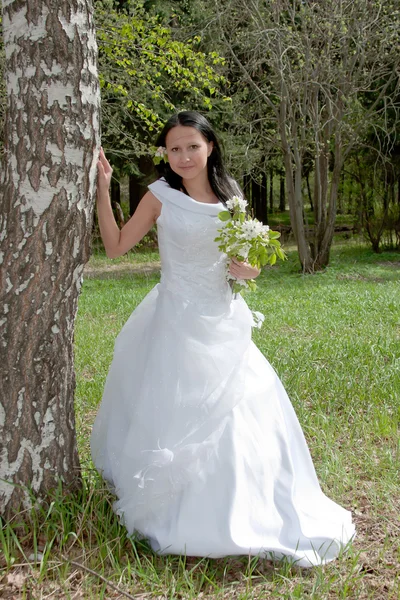 Jovem mulher no vestido de noiva no verão em um parque — Fotografia de Stock