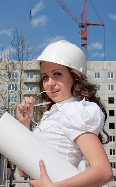 Junge Frau mit Helm und Dokumenten in der Hand — Stockfoto