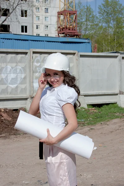 Junge Frau mit Helm und Dokumenten in der Hand — Stockfoto