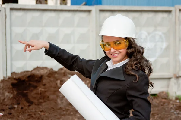 Junge Frau mit Helm und Dokumenten in der Hand — Stockfoto