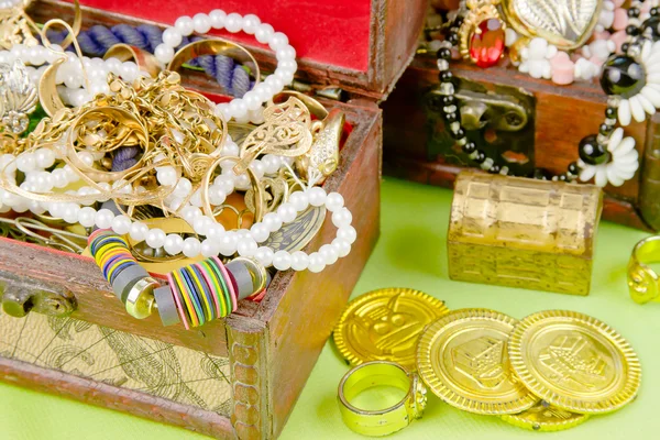 Açık yeşil arka planda hazineleri olan iki küçük kutu.