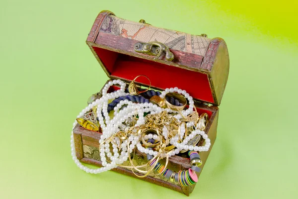 Small box with treasures on a light green background — Stock Photo, Image