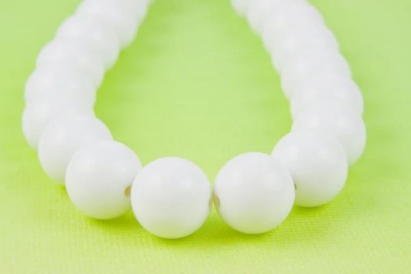 Woman white beads on a light green background — Stock Photo, Image