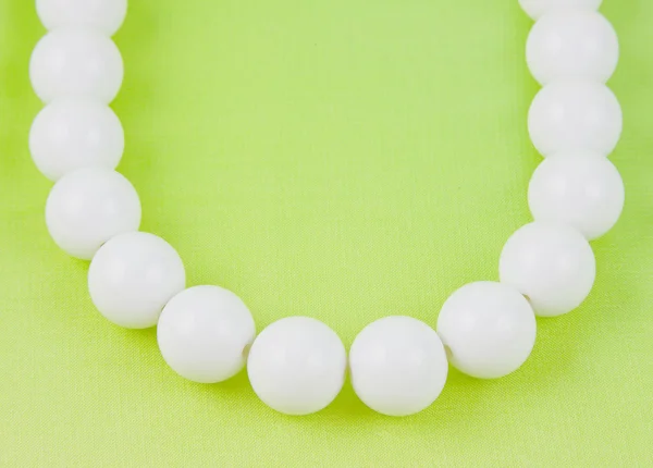 Woman white beads on a light green background — Stok fotoğraf