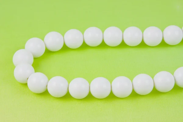 Woman white beads on a light green background — Stok fotoğraf