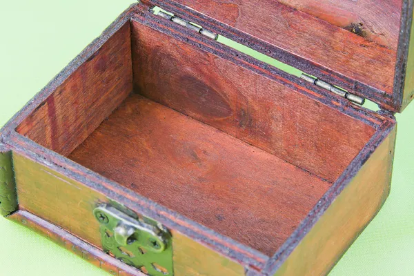 Caja pequeña abierta decorativa sobre un fondo verde claro — Foto de Stock