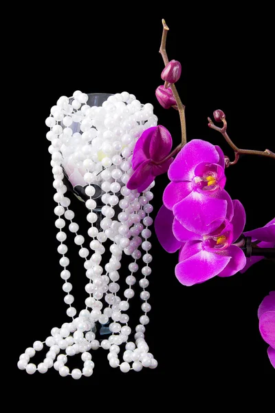 Flowers of pink orchid and beads from white pearls on a black — Stock Photo, Image