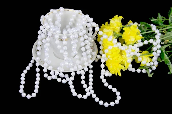 Yellow chrysanthemums and beads are pearls on a black background — Stock Photo, Image