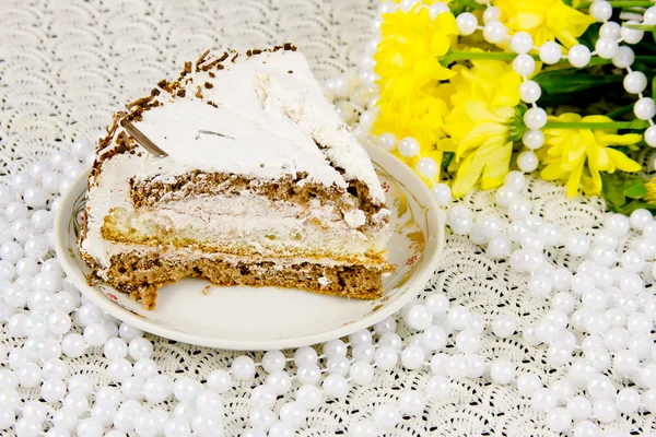 Chrysanthèmes jaunes, morceau de gâteau et perles — Photo